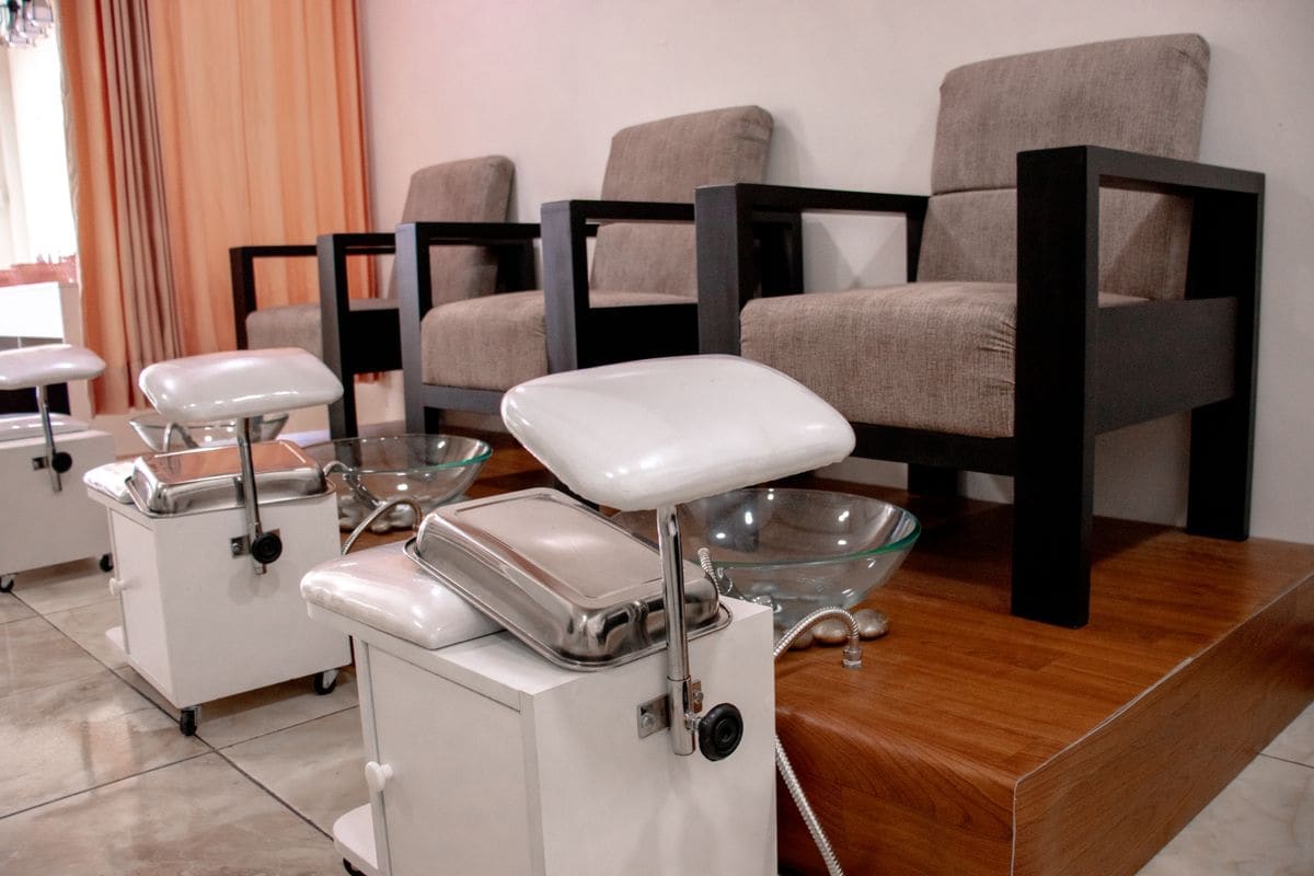 Pedicure chairs with white footrests and basins