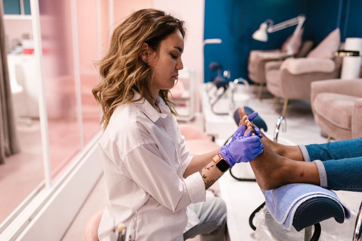A technician giving a pedicure in a bright room