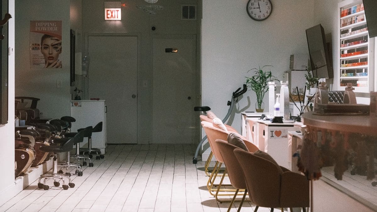 A salon room with pale chairs and mirrors
