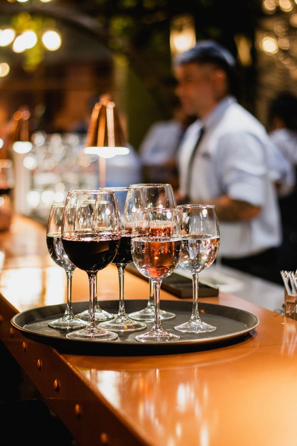 Glasses of red and rosé wine on a tray at the bar