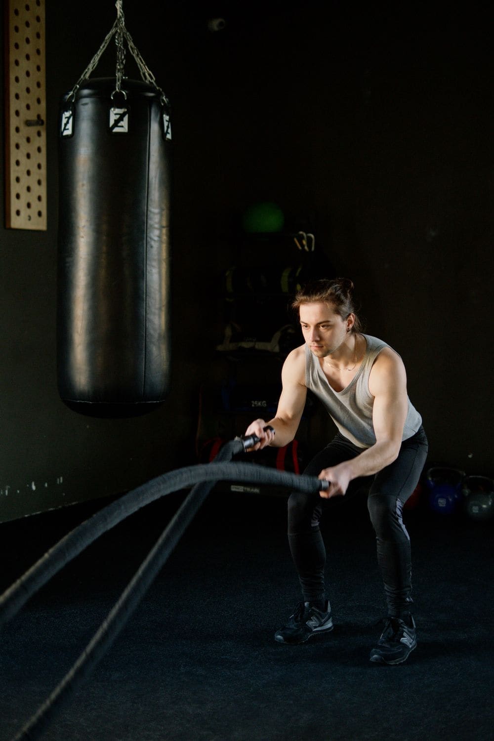 A man working battle ropes in a gym