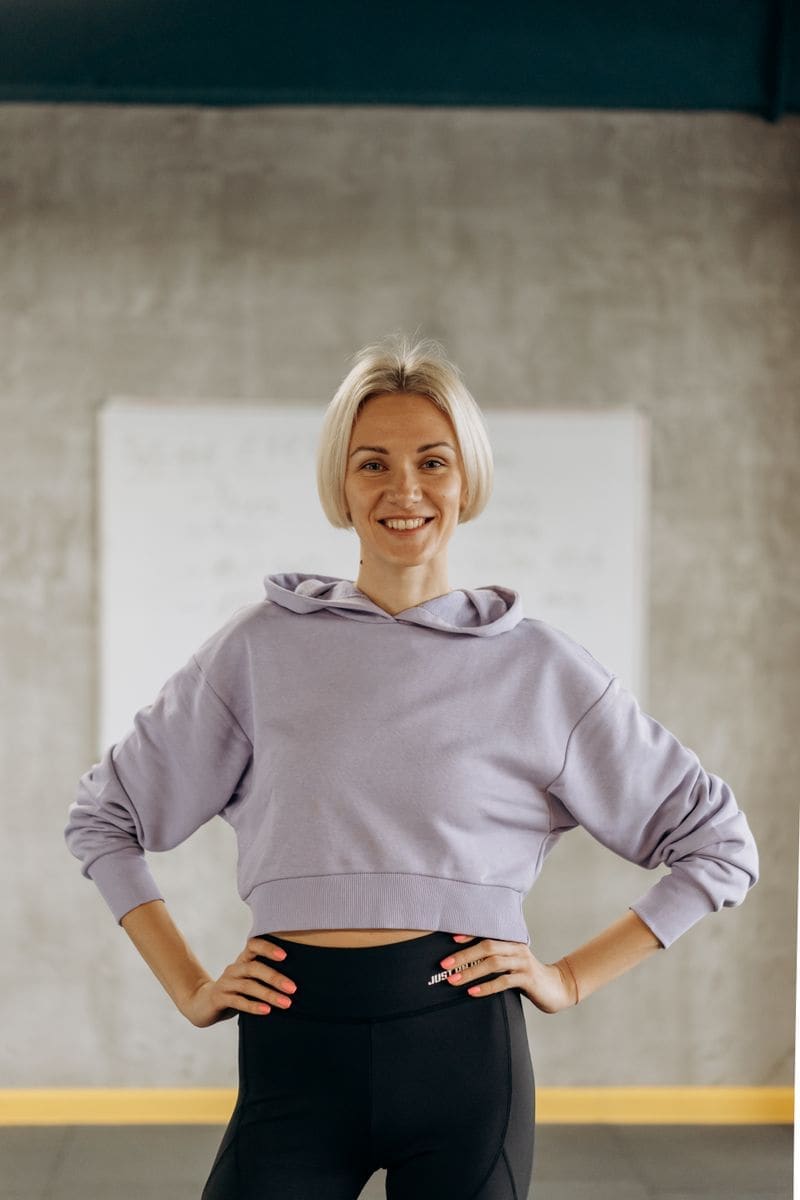 A smiling coach in a lilac hoodie