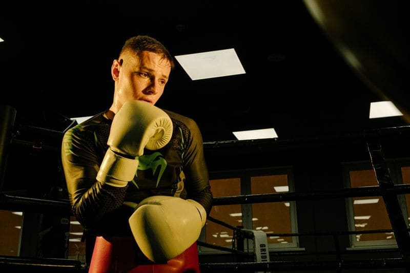 A coach in boxing gloves in a gym