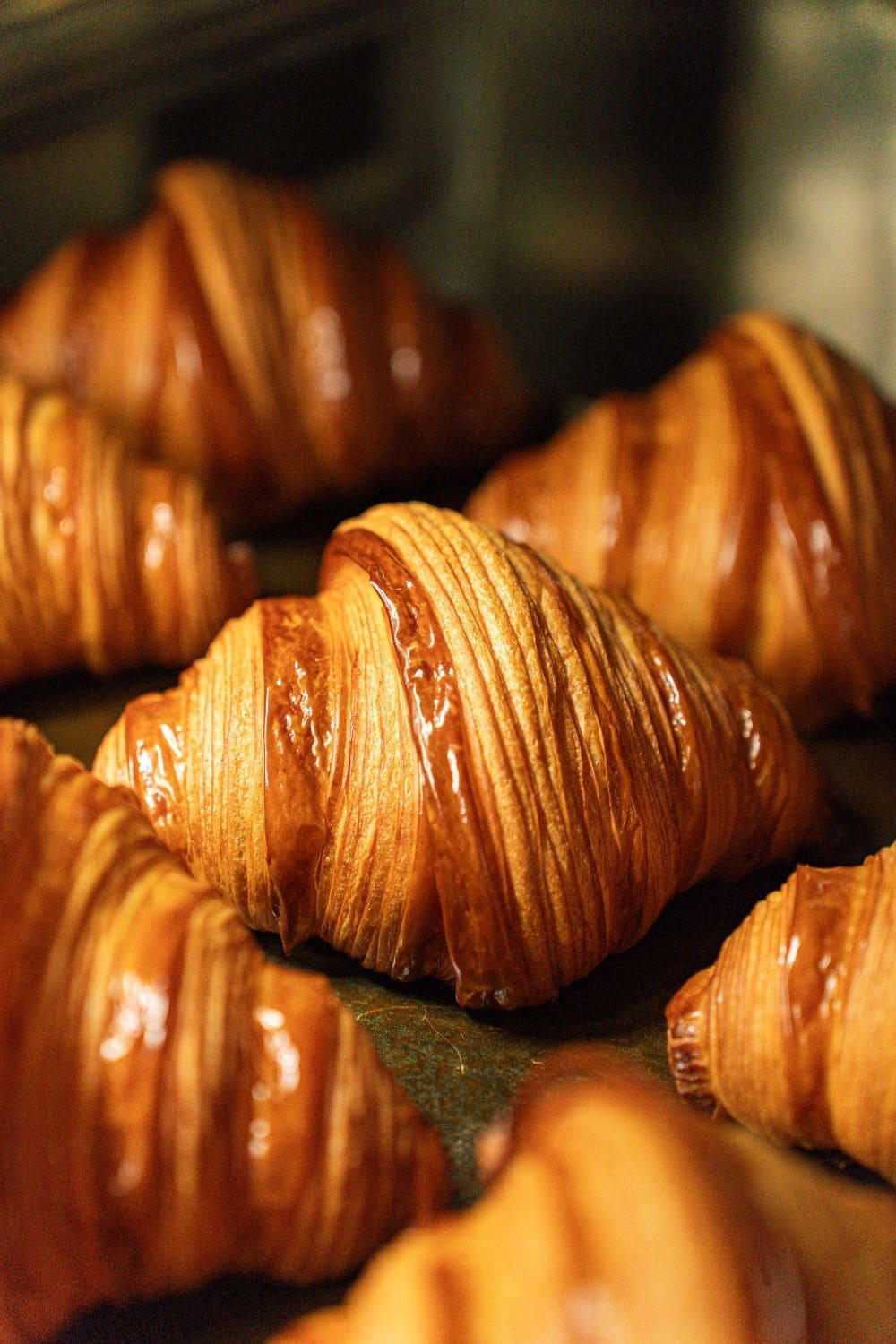 A golden croissant with flaky layers, close up