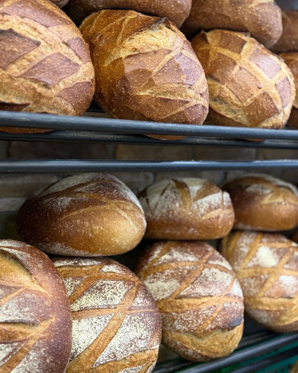 Round sourdough loaves stacked on bakery shelves