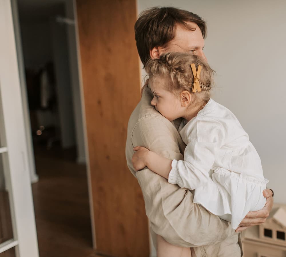 A parent holding a small child close in a quiet room