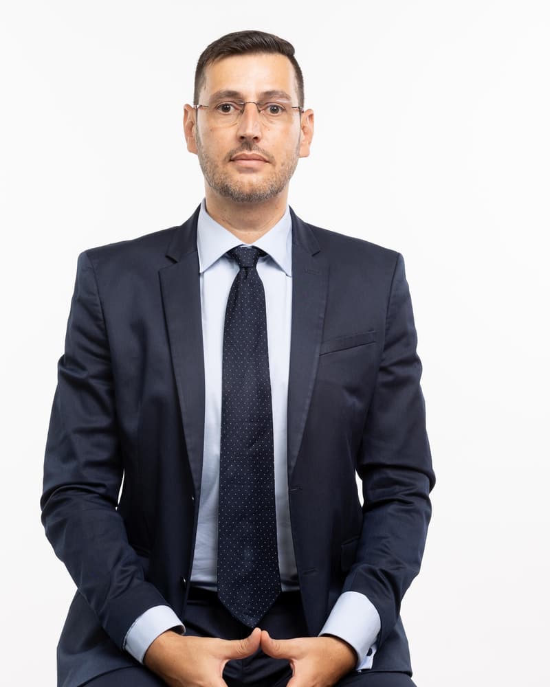 Casey Sample in a dark suit, seated