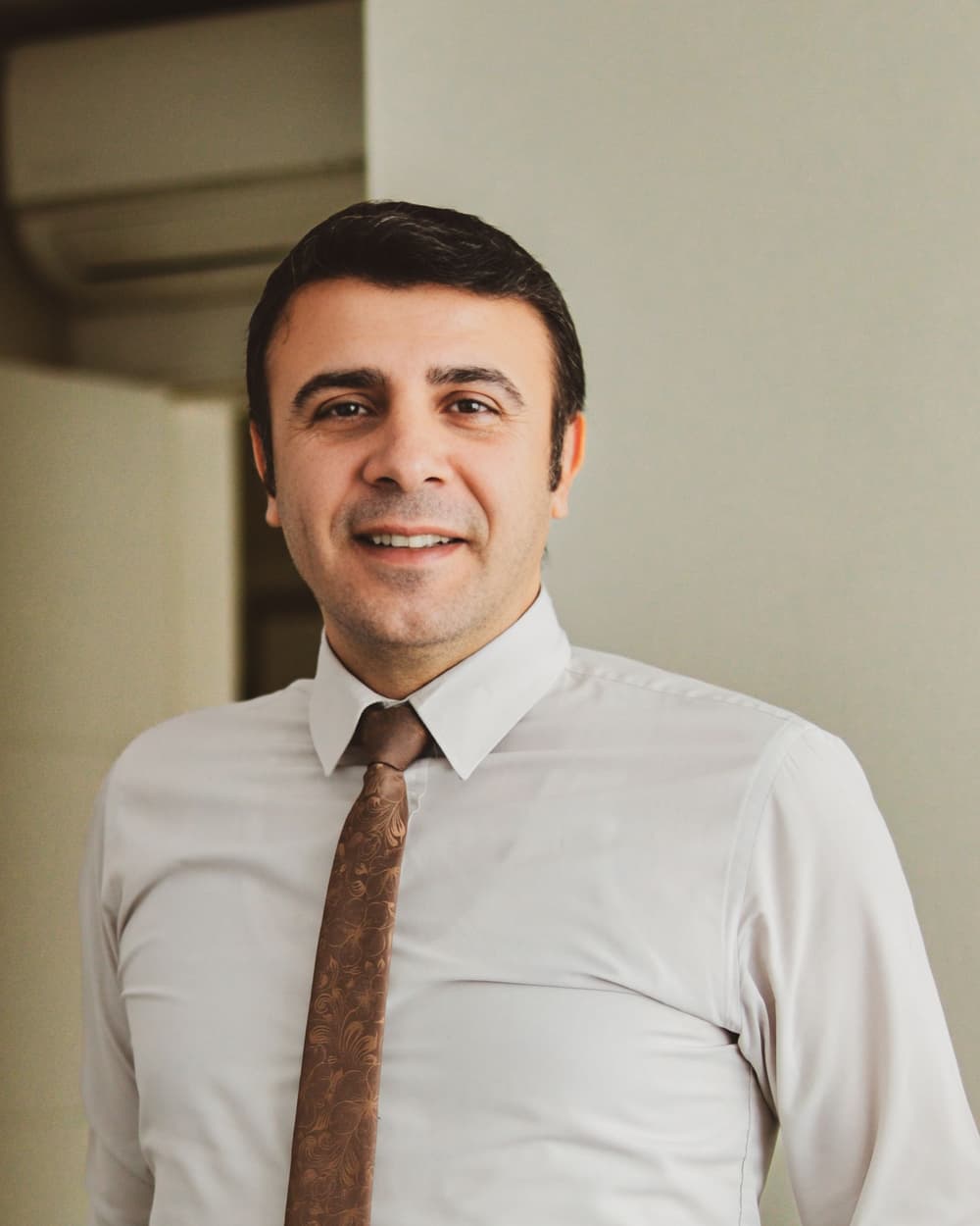 Jesse Sample smiling in a shirt and tie