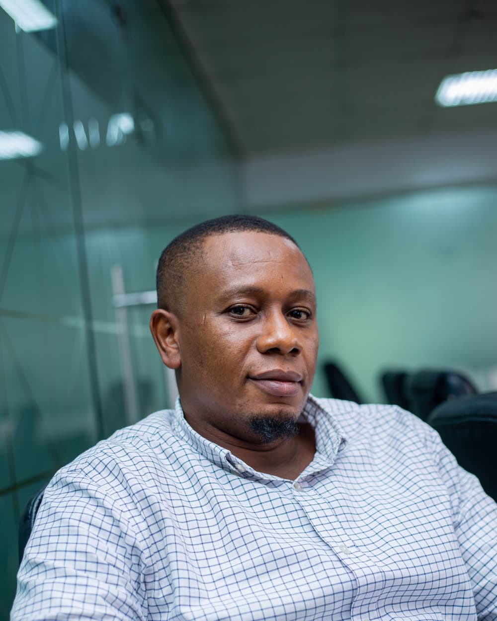 Pat Sample in a checked shirt, sitting in an office